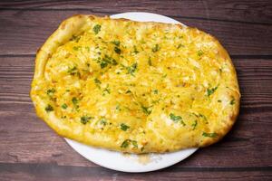 Tandoori Garlic chili nan, naan, nun served in dish isolated on wooden table top view indian spices food photo