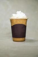 Iced Blended Hazelnut Latte coffee served in disposable cup isolated on grey background side view of cafe dessert photo