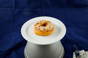 Peanut Butter Donut with knife served in plate Isolated on blue background side view of baked breakfast food photo