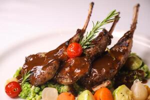 NEWZELAND LAMB CHOPS or mutton CHOP with tomato, onion and potato served in dish isolated on table closeup top view of arabian food photo