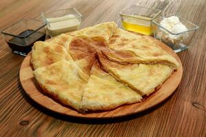 Unleavened bread with dip served in wooden board isolated on table side view of arabic food photo