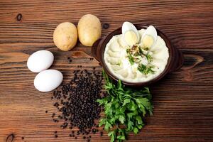 Mashed potatoes with boiled eggs coriander and black pepper served in dish isolated on table top view of arabian food photo