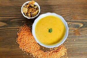 Lentil soup with crackers served in bowl isolated on table top view of arabian food photo