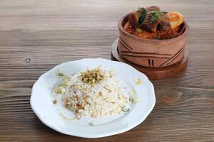 Potato casserole with meat with steam rice served in dish isolated on wooden table side view of arabic food photo