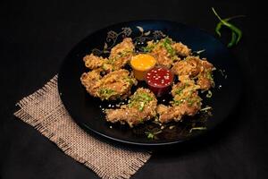 Crispy Chicken Wings with chilli sauce and mayo dip served in dish isolated on napkin dark background top view of indian fastfood photo