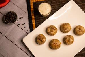 Stuffed Mushroom with shrimp meat balls dumplings with dip, black pepper and garlic chilli sauce served in dish isolated on napkin closeup top view on wooden table italian dim sum food photo