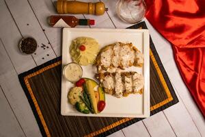 Grilled Mushroom chicken piccata with salad, dip, black pepper and garlic chilli sauce served in dish isolated on napkin top view on wooden table italian food photo