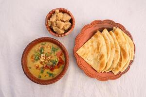 Desi breakfast, haleem, halim, dhaleem, halwa and paratha served in dish isolated on background top view of bangladesi breakfast photo