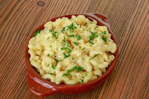 Pasta salad white sauce served in dish isolated on wooden table side view of arabic food photo