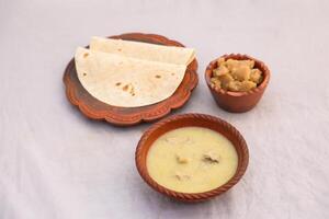 desi breakfast Chicken soup, Halwa and chapatti served in dish isolated on background top view of bangladesi breakfast photo