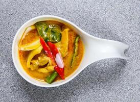 Spicy chicken yellow curry served in dish isolated on grey background top view of hong kong food photo