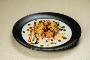 Spicy Doi Bora or dahi bhallay, bhalla, vada, yogurt and pomegranate seeds served in dish isolated on table top view of indian, bangladeshi and pakistani street food photo