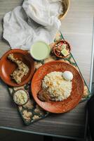 Chicken pulao biryani, Morog Pulao Combo with salad, borhani and Chui Pitha served in dish isolated on mat top view of indian and bangladeshi food photo