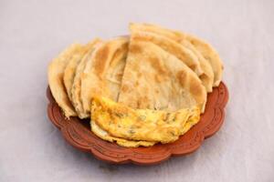 desi breakfast egg omelet and paratha served in dish isolated on background top view of bangladesi breakfast photo