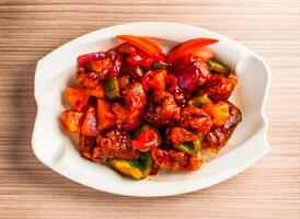 fried ribs with pineapple, tomato and bell pepper served in dish isolated on table top view of hong kong food photo