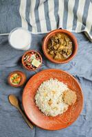 Beef Chui Jhal Combo with pulao rice, shami kabab, korma karahi, kala buna, boondi rabri, borhani and salad served in dish isolated on mat top view of indian and bangladeshi food photo