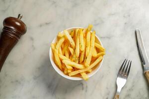 francés papas fritas Cubeta servido en plato aislado en mármol antecedentes parte superior ver en hong kong comida foto