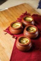 Firni, phirni anf kheer with nuts served in pot isolated on mat top view of indian, bangali and pakistani dessert mithai photo