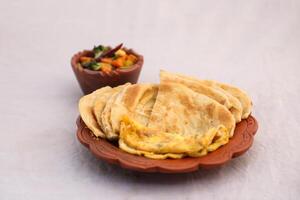 desi breakfast mixed vegetables, egg omelet and paratha served in dish isolated on background top view of bangladesi breakfast photo