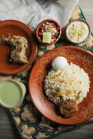 Chicken pulao biryani, Morog Pulao Combo with salad, borhani and Chui Pitha served in dish isolated on mat top view of indian and bangladeshi food photo