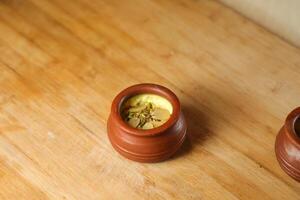 Firni, phirni anf kheer with nuts served in pot isolated on mat top view of indian, bangali and pakistani dessert mithai photo