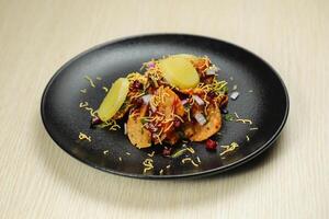 Aloo Papri Chaat, dahi bhalla, bhallay, potato, crackers, masala and yogurt served in plate isolated on background top view of indian spices street food photo