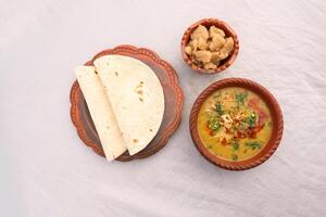 Desi breakfast, haleem, halim, dhaleem, halwa and chapatti served in dish isolated on background top view of bangladesi breakfast photo