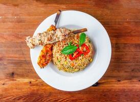 garlic fried rice with skewer served in dish isolated on wooden table top view of hong kong food photo