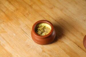 Firni, phirni anf kheer with nuts served in pot isolated on mat top view of indian, bangali and pakistani dessert mithai photo