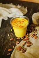 Badam sharbat, Almond milk syrup with saffron served in glass isolated on table top view of drink photo