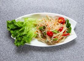 papaya salad with tomato, carrot and lettuce leaf served in dish isolated on grey background top view of hong kong food photo