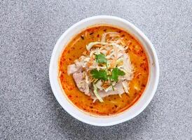 thai rice noodle in laksa soup with beef served in bowl isolated on grey background top view of hong kong food photo