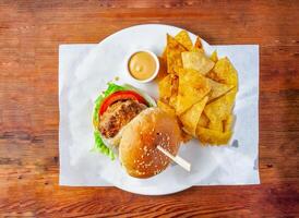 bombay chicken burger with mayonnaise dip and crackers served in dish isolated on wooden table top view of hong kong food photo