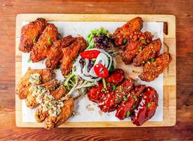 fried chicken wings platter with salad servedon cutting board isolated on wooden table top view of hong kong food photo