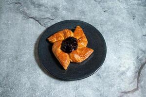 Blueberry Danish puff pastry filled with sweet cheese served in plate isolated on background top view of baked food indian dessert photo