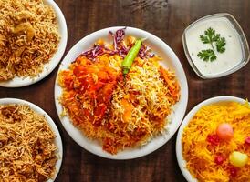 clasificado biryani, pulao con carne de res, pollo y zarda color ful arroz servido en plato aislado de madera antecedentes parte superior ver indio dulce y pakistaní postre comida foto