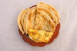 desi breakfast egg omelet and paratha served in dish isolated on background top view of bangladesi breakfast photo