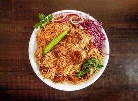 Bannu beef pulao rice with salad, onion and cabbage served in plate isolated wooden background top view indian spices and pakistani food photo