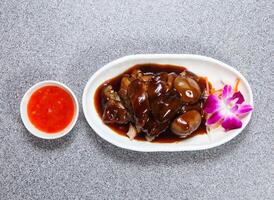 Braised Pork Trotter in thai style with sauce served in dish isolated on grey background top view of hong kong food photo