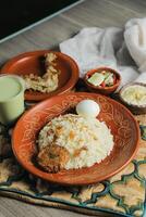 Chicken pulao biryani, Morog Pulao Combo with salad, borhani and Chui Pitha served in dish isolated on mat top view of indian and bangladeshi food photo