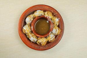 Doi Fuchka or pani puri and gol gappay with sour water, yogurt served in dish isolated on table top view of indian, bangladeshi and pakistani street food photo