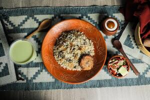 Beef Tehari Combo with shami kabab tikki, salad, borhani and baked gulab jamun served in dish isolated on mat top view of indian and bangladeshi food photo