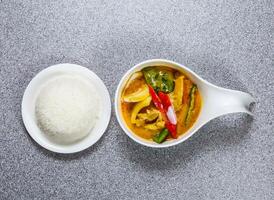 Spicy chicken yellow curry with rice served in dish isolated on grey background top view of hong kong food photo