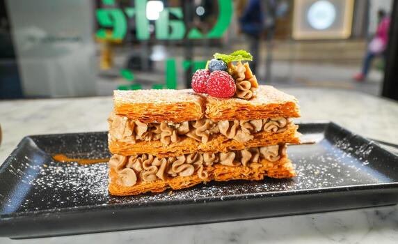 Millefeuille Praline with raspberry, and blueberry served in dish isolated on marble background top view on hong kong food photo