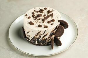 Oreo Cheesecake include chocolate, cream, sugar with fork and flowers served in plate isolated on napkin side view of cafe food photo