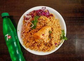 Spicy Chicken pulao with 7 up bottle 345 ml, onion and cabbage served in plate isolated wooden background top view indian spices and pakistani food photo