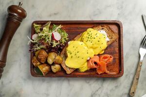 huevos royale con pan, carne, ensalada, tomate y patata servido en plato aislado en mármol antecedentes parte superior ver en hong kong comida foto