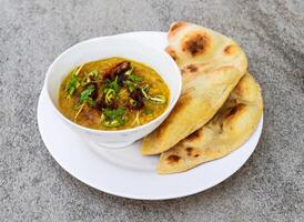 picante pollo haleem con frito cebolla, naan, Roti servido en plato aislado en antecedentes parte superior ver de indio especias y pakistaní comida foto