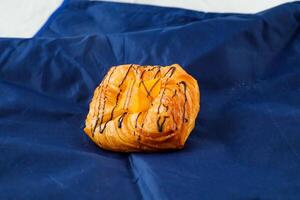 melocotón danés Pastelería soplo aislado en azul servilleta lado ver de francés desayuno horneado comida articulo foto