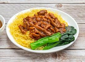 noodles with soy bean paste served in dish isolated on wooden table top view hong kong food photo